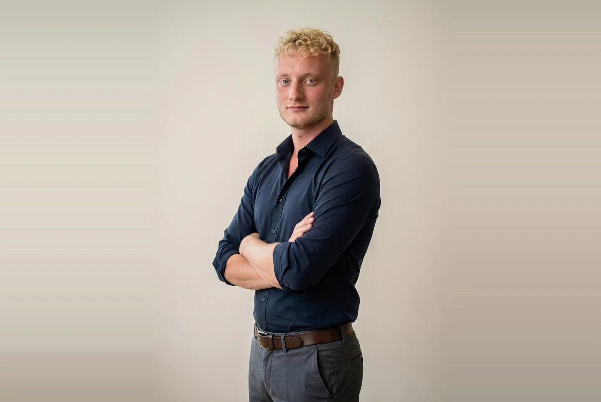 Marius May, Software- und Webentwickler aus Penig bei Chemnitz, mit verschränkten Armen im dunkelblauen Hemd vor hellem Hintergrund